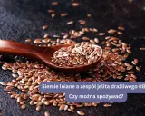 Łyżka pełna siemienia lnianego rozsypanego na ciemnym tle. Siemię lniane na jelita - wsparcie dla układu trawiennego.