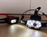 Dwie czołówki Petzl, gotowe na nocne bieganie. Jedna czerwona, druga z wieloma diodami.